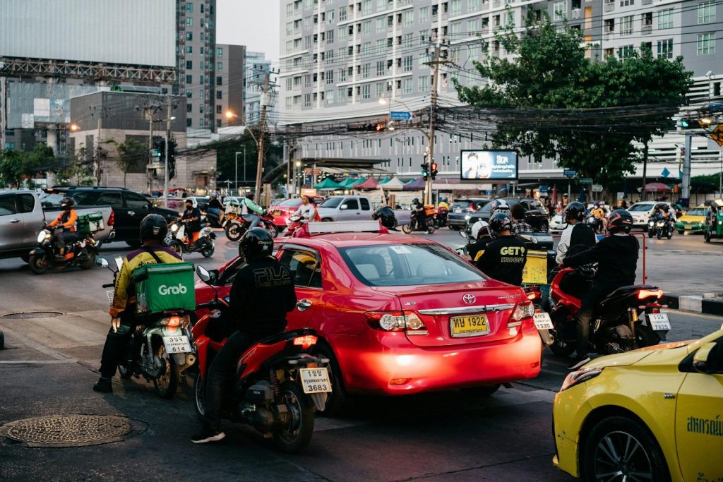 Starker Verkehr an einer Kreuzung in Bangkok mit Autos und Motorrädern