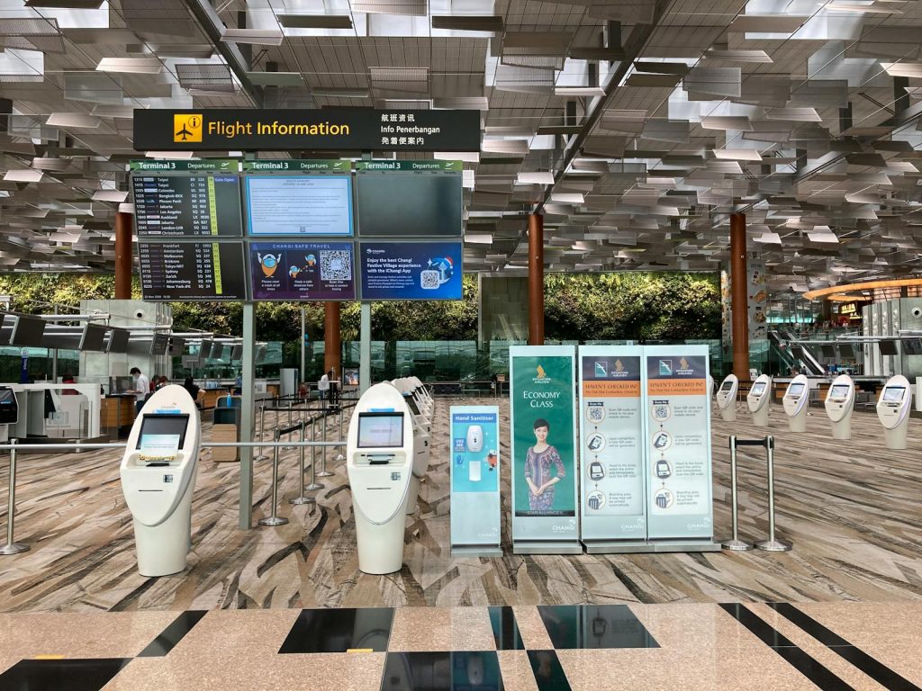Spacious airport lobby featuring flight information displays and self-check-in kiosks.
