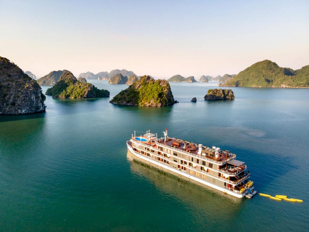 A luxury cruise ship navigates the scenic limestone islands of Halong Bay in Vietnam.