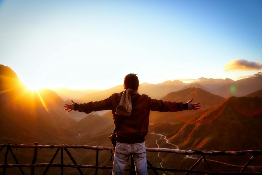 Silhouette of a person embracing the scenic sunset over the mountains in Tam Đường, Vietnam.