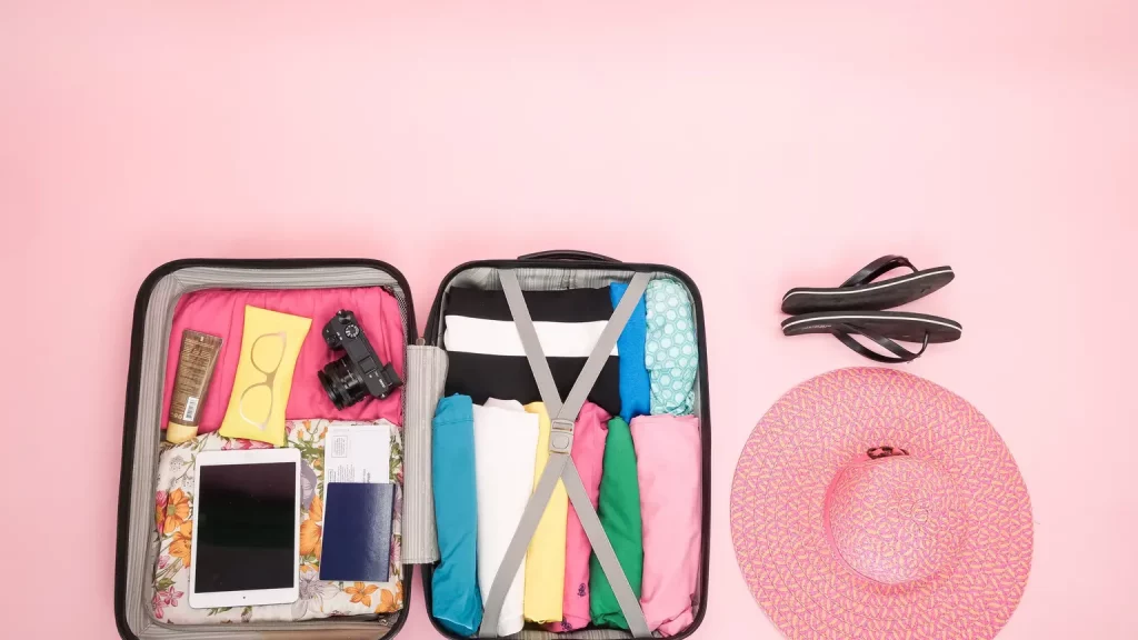 Übersichtlich gepackter Rollkoffer mit Kleidung und Reiseutensilien