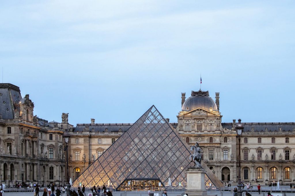 Capture of the Louvre Pyramid in Paris with evening lighting highlighting the historic architecture.