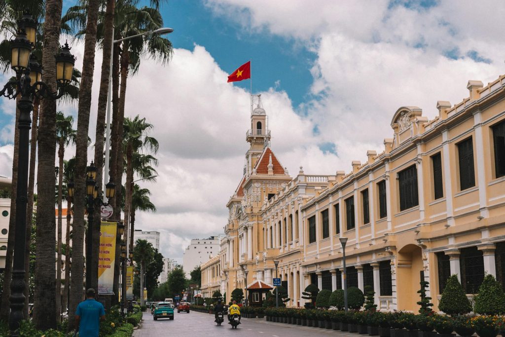 Reizvoller Straßenblick auf das Rathaus von Ho-Chi-Minh-Stadt mit der vietnamesischen Flagge.