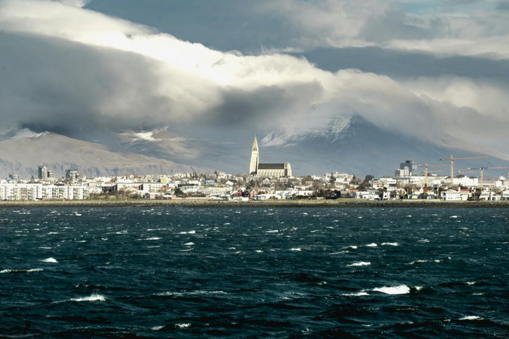 A stunning view of Reykjavík's skyline featuring the iconic Hallgrímskirkja church and ocean in Iceland.