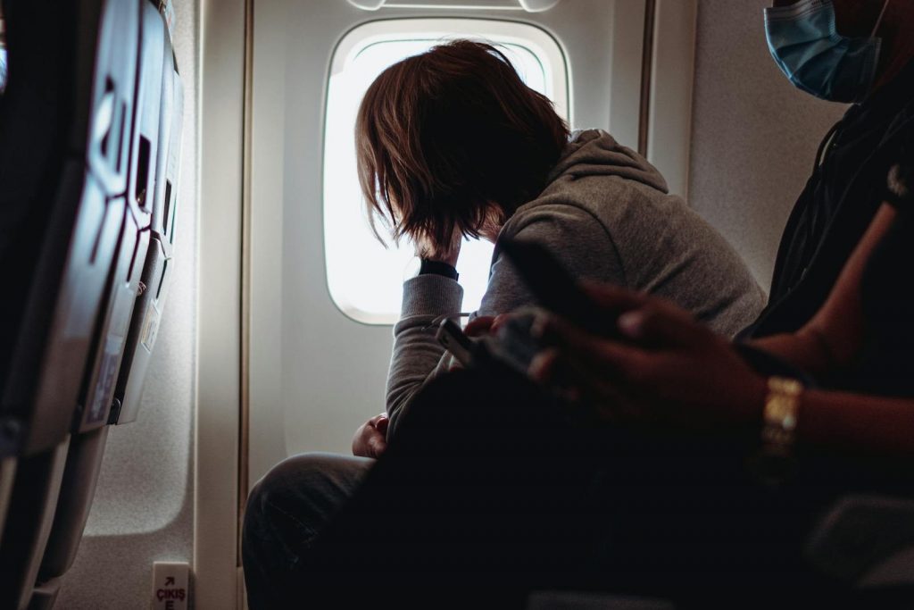Passagier blickt aus dem Flugzeugfenster während des Fluges
