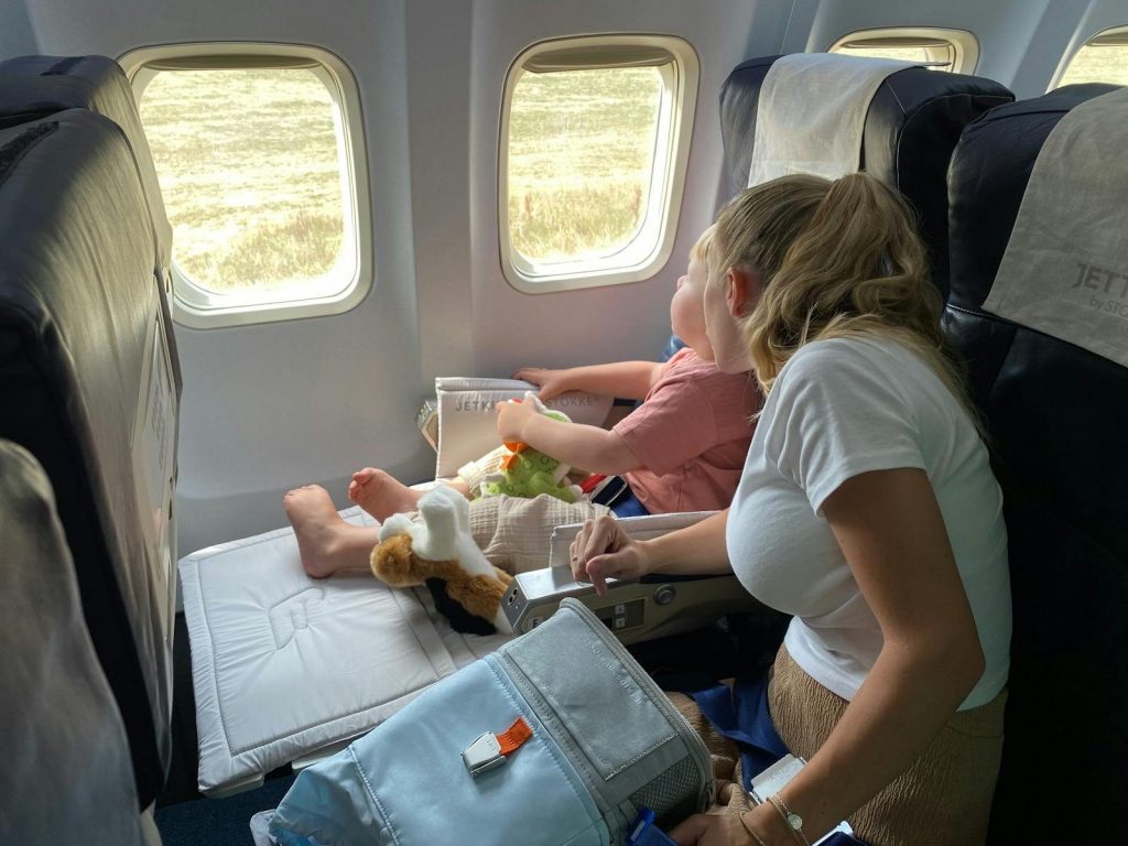 Mutter und Kind im Flugzeug mit Blick aus dem Fenster während des Fluges