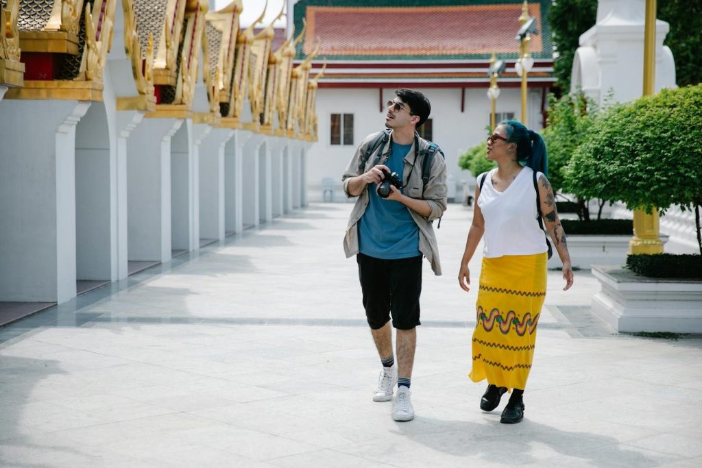 Reisepaar besucht einen Tempel in Thailand mit angemessener Kleidung