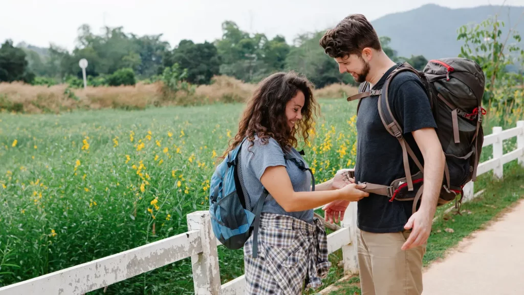 Backpacker testet Passform und Hüftgurt eines beladenen Reiserucksacks