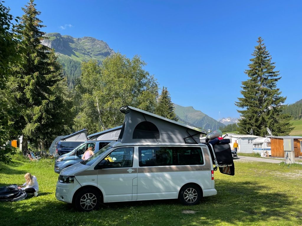 Moderner Campingplatz mit Wohnmobilen und Zelten am See – ideal für Camping-Anfänger.