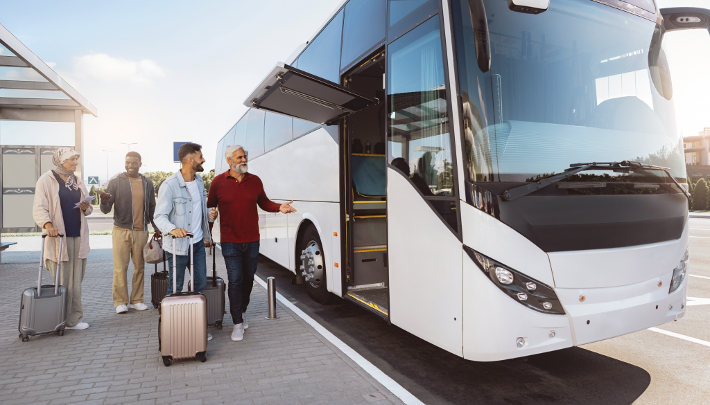 Reisende mit Koffern vor einem modernen Reisebus vor der Abfahrt nach Spanien