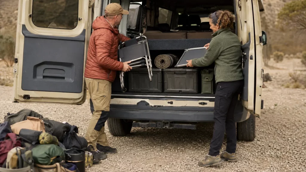 Paar verstaut Campingstühle und Ausrüstung geordnet im Campervan